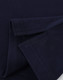 A close-up of a navy blue cotton stretch polo shirt, showcasing the fabric and folded sleeves. It features a logo.