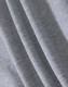A close-up of light grey fabric, showcasing the soft texture of a fleecy material.