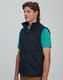 A men's softshell vest in navy blue, featuring a zip front and side pockets, worn over a green shirt.
