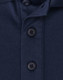 A navy blue polo shirt featuring a button placket and a logo. The fabric is a sustainable poly/cotton blend.
