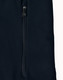 A dark navy softshell jacket featuring a zippered pocket and a sleek design. The jacket also has a logo.