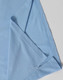 A light blue polo shirt featuring a folded sleeve, with a subtle branding logo.