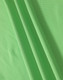 A close-up of soft, textured fabric in vibrant green, showcasing the material of a polo shirt.