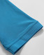 A close-up of a turquoise polo shirt sleeve, showcasing its textured fabric and cuff detail.