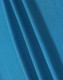 A close-up of blue fabric showcasing a textured weave, ideal for polo shirts. The fabric has a smooth appearance.
