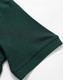 A close-up of a dark green polo shirt sleeve featuring a logo. The fabric appears smooth and lightweight.