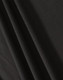 A close-up of black fabric showcasing texture and drape, featuring a subtle weave pattern.