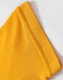 A close-up of a folded yellow polo shirt sleeve with a textured fabric detail. The shirt features a logo.