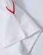 A white polo shirt featuring red accents on the sleeves and a logo.