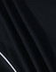 A close-up of a black polo shirt fabric with textured pattern and a contrasting white trim.