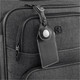 A black luggage tag with an AirTag holder attached to a grey suitcase, featuring a logo on the suitcase.