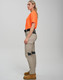 Work pants in light khaki with black accents, paired with an orange shirt. The model stands in profile.