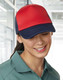 A red and navy Contrast Trucker Cap is worn by a woman with a smile, set in a bright indoor environment.
