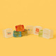 Jelly Cube sensory toys in various colours, featuring a promotional logo on one cube against a bright yellow background.