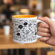 A coffee mug with a vibrant orange interior, decorated with various coffee-related designs and a branding logo.