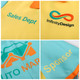 A vibrant yellow and teal Hawaiian button-up shirt featuring an orange collar and branding details.