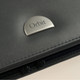 A black leather folder featuring a metallic grey logo badge with the word "Orbit".