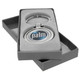 A silver keychain with a circular emblem in a grey box with a soft interior. The keychain includes a logo.