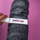 A lint remover in white with a logo, removing lint from a black puffer jacket against a pink background.