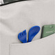 A grey lunch cooler featuring a front pocket with blue utensils and a green item inside.