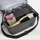 A drink bag in grey containing champagne, chocolates, and a box, with a silver insulated lining.