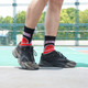 Crew sport socks featuring a basketball design in red and black, worn with black athletic shoes on a sports court.