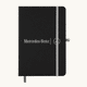 A black A5 notebook with an elastic closure and a logo on the front, featuring a grey band and bookmark.