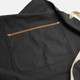 A dark grey canvas apron with a brown pocket and cream-coloured straps.