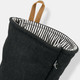 A black oven mitt with a striped interior and a hanging loop, featuring a small logo.