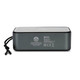 A grey Bluetooth speaker with a mesh top and a side strap, featuring branding and various technical labels on the back.