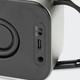 A black Swiss Peak 10W Bass Speaker featuring power and audio input ports. The design includes a textured surface.
