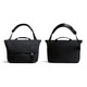 A black messenger bag with adjustable strap, featuring a flap closure and carry handles, along with a subtle logo.