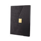 A black notebook with a textured cover and a gold clasp. The design features a unique angled flap and branding.