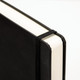 A5 daily diary in black, featuring a sleek cover and an elastic band closure.