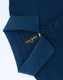 A navy blue ladies polo shirt with a collared neckline and buttons, featuring a brand tag inside.
