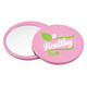 A pink circular makeup mirror with a reflective surface and a logo featuring green design elements.