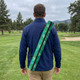 A green Full Colour Cooler Sling Bag is seen slung across a person's shoulder as they walk on a golf course.