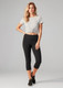 A model wears women's black 3/4 leggings paired with a grey knotted t-shirt. The leggings have a logo on the waistband.