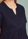 A women's navy tunic scrub top featuring a notch neckline and button detail. The top has a relaxed fit.