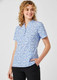 A blue tunic with a stardust print, featuring short sleeves and a collar, displayed on a smiling model.