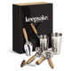 A cocktail set featuring stainless steel utensils and wooden accents, displayed in a sleek black box with a branding logo.