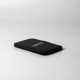 A black pocket mirror with a sleek, minimalist design, featuring a logo on its surface.