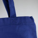 A blue 450gsm Hawaiian canvas tote bag with sturdy handles and a textured finish, featuring a logo.