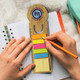 A bamboo ruler bookmark in natural colour, featuring a round top and vibrant sticky notes, positioned on a notebook. A bamboo ruler bookmark in natural colour, featuring a round top and vibrant sticky notes, positioned on a notebook.