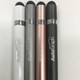 Four metal pens in silver, rose gold, grey, and black, featuring a logo on each pen. Four metal pens in silver, rose gold, grey, and black, featuring a logo on each pen.