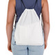 A white drawstring backpack with black straps, shown from the back on a person wearing a fitted top and jeans.