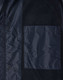 A dark navy unisex jacket featuring a large chest pocket and snap button closures. Includes a logo on the fabric.