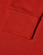 A close-up of a red long sleeve polo shirt, featuring a ribbed cuff and textured fabric.