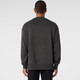 A grey jumper with long sleeves and a relaxed fit, featuring a logo on the back.