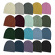 A series of cable knit beanies in various colours, including cream, grey, green, purple, and burgundy, arranged in a grid.